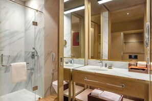 Une salle de bain moderne avec une douche à parois de verre, un grand miroir et un meuble-lavabo.