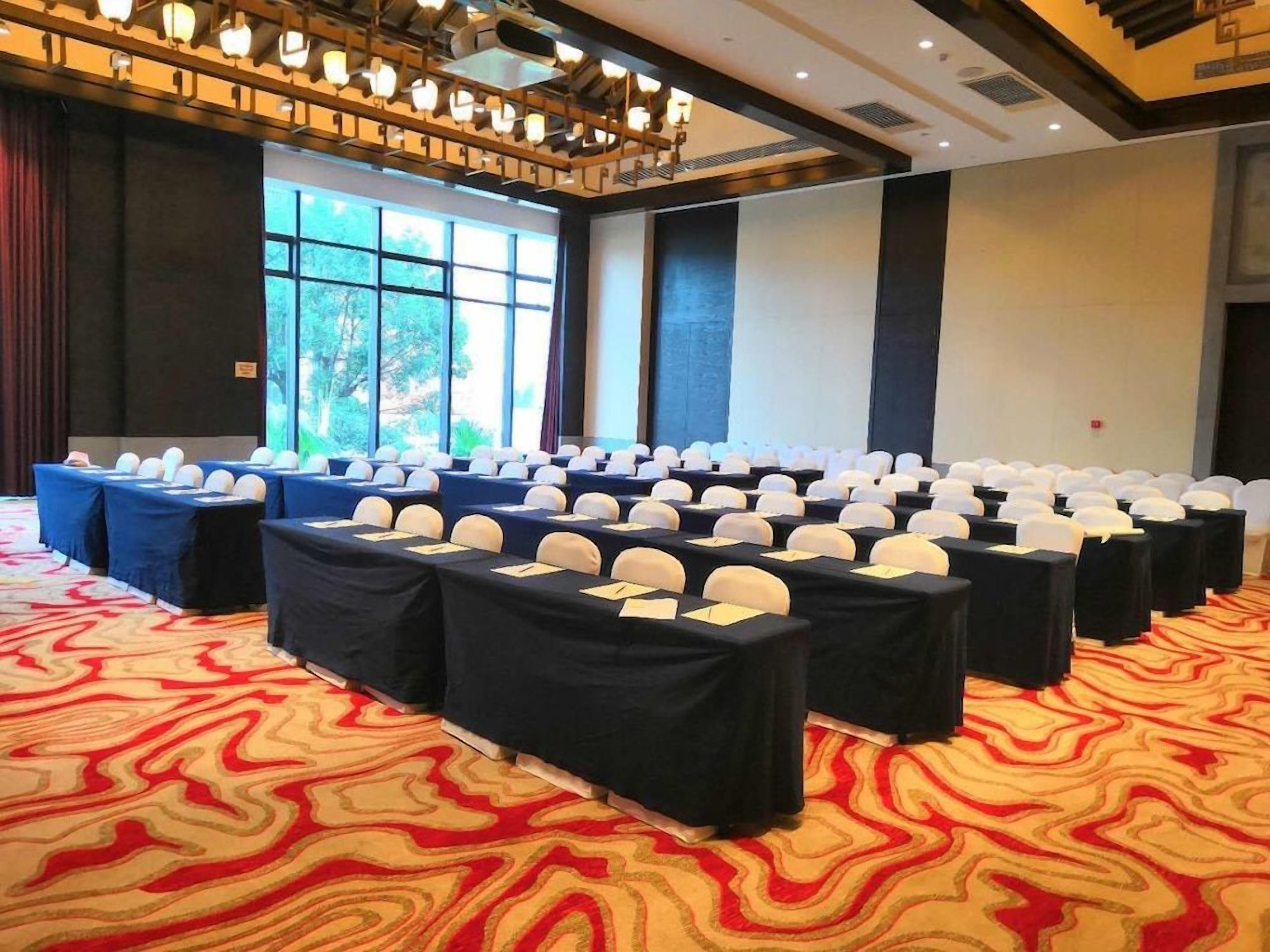 A conference room with rows of tables, chairs, and name cards.