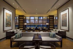 A spacious lobby with a central seating area, bookshelves, and artwork on the walls. - Amitabha Hotel (Fuzhou)