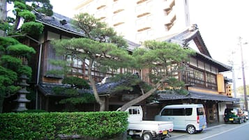 Un edificio japonés tradicional con estructura de varios pisos, vigas de madera y tejado de tejas.
