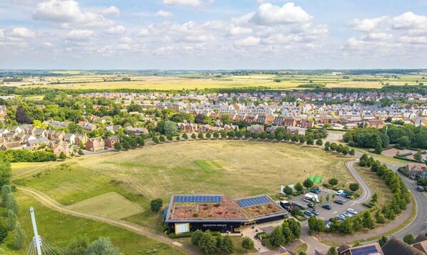 A residential area with houses, a large open field, and a building with solar panels.