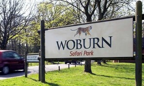 A sign for Woburn Safari Park with a tiger illustration.