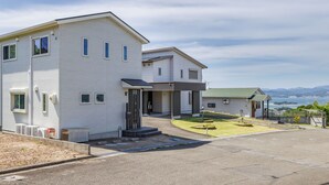 A two-story residential building with a covered entrance and a small garden area. - Hopehills Hiramatsutei (Shirahama)