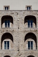 A stone building with multiple arched windows and balconies.