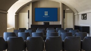 A conference room with a large screen displaying the logo of Dogana Resort. - Dogana Resort (Molfetta)