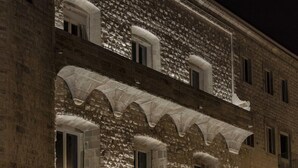 A stone building with arched windows and a balcony. - Dogana Resort (Molfetta)