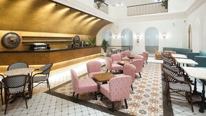 Un vestíbul ampli amb una zona de recepció central, diverses zones d'estar i un sostre alt amb il·luminació decorativa.