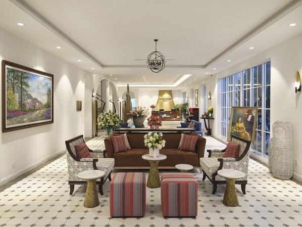A spacious lobby with a central reception desk, comfortable seating areas, and large windows providing natural light.
