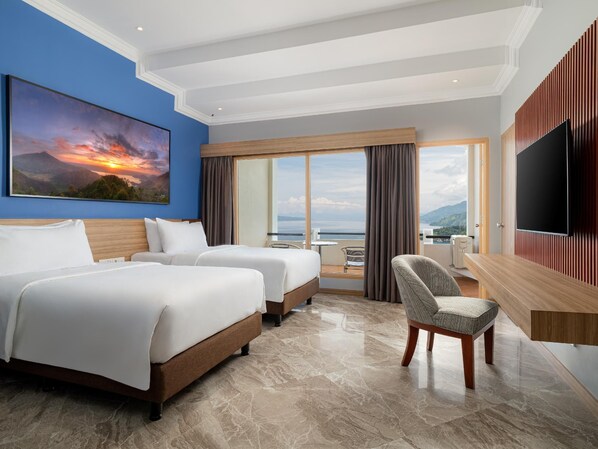 A hotel room with two beds, a TV, a chair, and a large window with a view. - Niagara Hotel Lake Toba Resorts (Parapat)