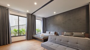A modern bedroom with a sofa, a bed, and a large window with curtains. - The Garden Capsule Hotel (Da Nang)