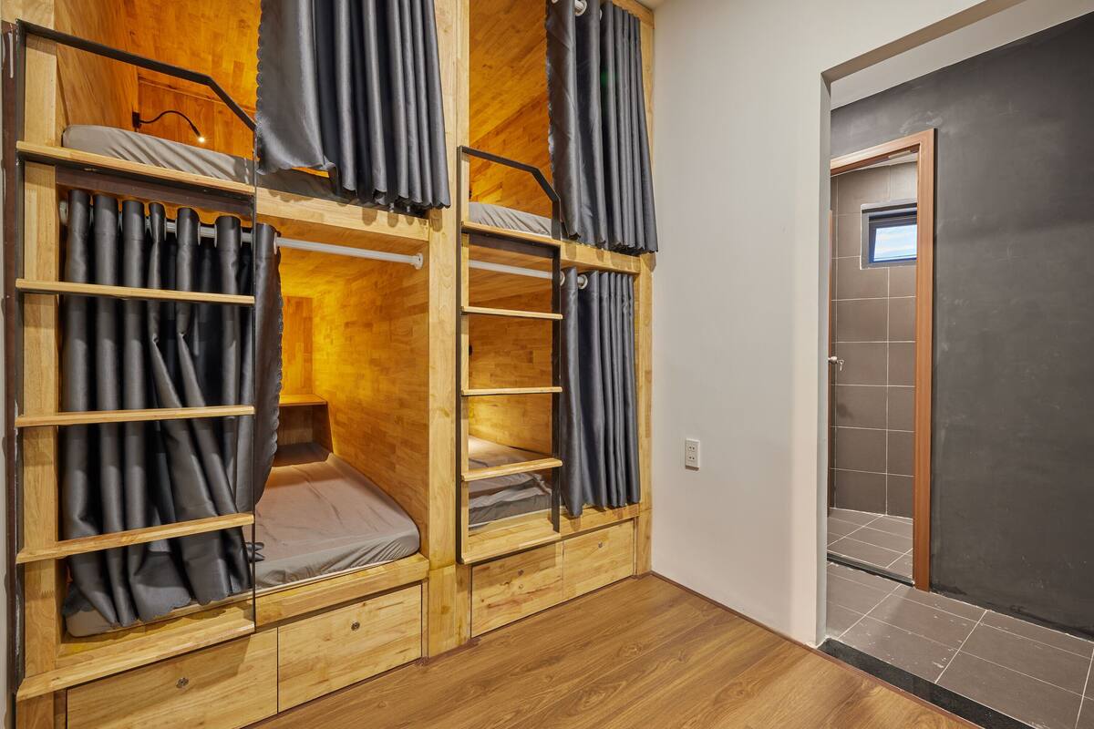A bunk bed room with wooden walls and a dark floor.