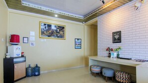 A modern kitchen with a white brick backsplash, a framed picture, and a Wi-Fi sign. - Yani Homestay by Zuzu (Padang)