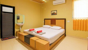 A hotel room with a bed, a bedside table, a mirror, an air conditioner, and a window with curtains. - Yani Homestay by Zuzu (Padang)