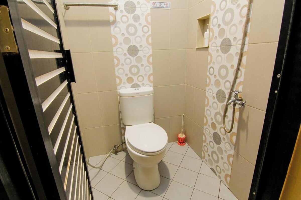 A small bathroom with a toilet, a shower, and a hand dryer.