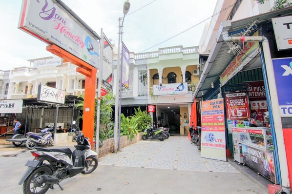 A street with shops, including a visible sign for 'Yani Homestay' and a 'Golden' store. - Yani Homestay by Zuzu (Padang)