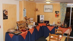 Una mesa de buffet con diferentes opciones de comida y una máquina de café.