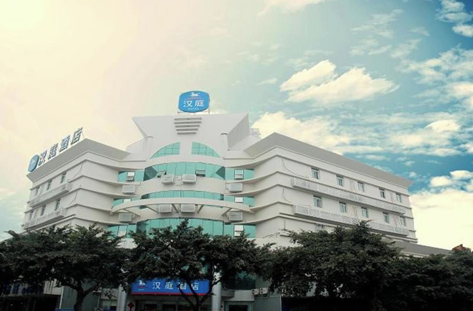A multi-story building with a prominent blue sign at the top, likely indicating a hotel or similar establishment.