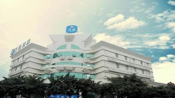 A multi-story building with a prominent blue sign at the top, likely indicating a hotel or similar establishment.