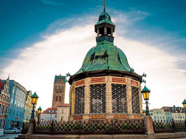 Un edificio histórico con una cúpula verde y una torre del reloj.