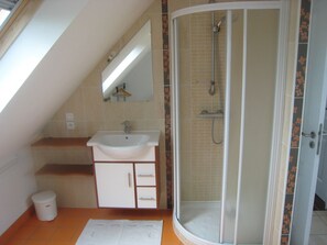 A bathroom with a white sink, a mirror, a shower enclosure, and a tiled floor. - Villa Panoramic sea view, last before the beach - bikes, paddles - Superb (Cléder)
