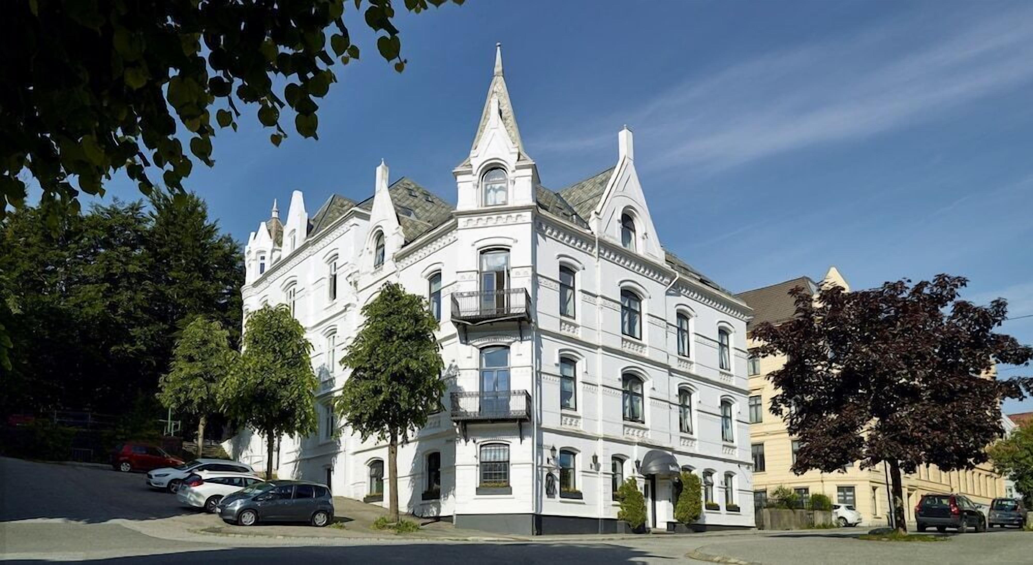 A historic white building with multiple stories, ornate architectural details, and a prominent tower.