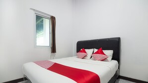Una habitación de hotel con una cama, una ventana con cortinas y una pared blanca.
