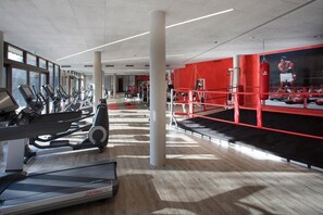 A gym with treadmills, stationary bikes, and a boxing ring. - Feuriger Tatzlwurm Berghotel & Spa BW Signature (Oberaudorf)