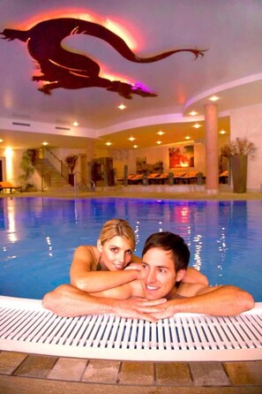 A swimming pool with a dragon mural on the ceiling, indoor lighting, and a view of the pool area. - Feuriger Tatzlwurm Berghotel & Spa BW Signature (Oberaudorf)