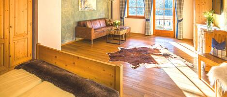 A cozy room with a wooden bed, a sofa, a coffee table, and a large rug.