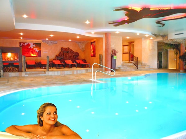 A swimming pool with a lounge area and a staircase leading to an upper level. - Feuriger Tatzlwurm Berghotel & Spa BW Signature (Oberaudorf)