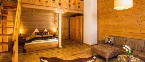 Un intérieur en bois avec un lit superposé, un canapé et un tapis en peau de vache.