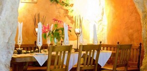 An indoor dining area with wooden chairs and tables, white tablecloths, and candle holders. - Feuriger Tatzlwurm Berghotel & Spa BW Signature (Oberaudorf)