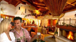 A cozy interior with a stone fireplace, wooden beams, and rustic decor. - Feuriger Tatzlwurm Berghotel & Spa BW Signature (Oberaudorf)