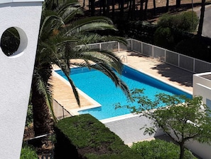 A rectangular swimming pool with a white deck and a white railing.