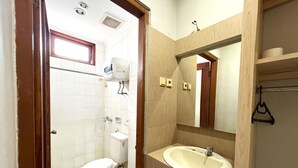 A bathroom with a toilet, a sink, and a shower. - OYO 3819 Hotel Winotosastro (Yogyakarta)