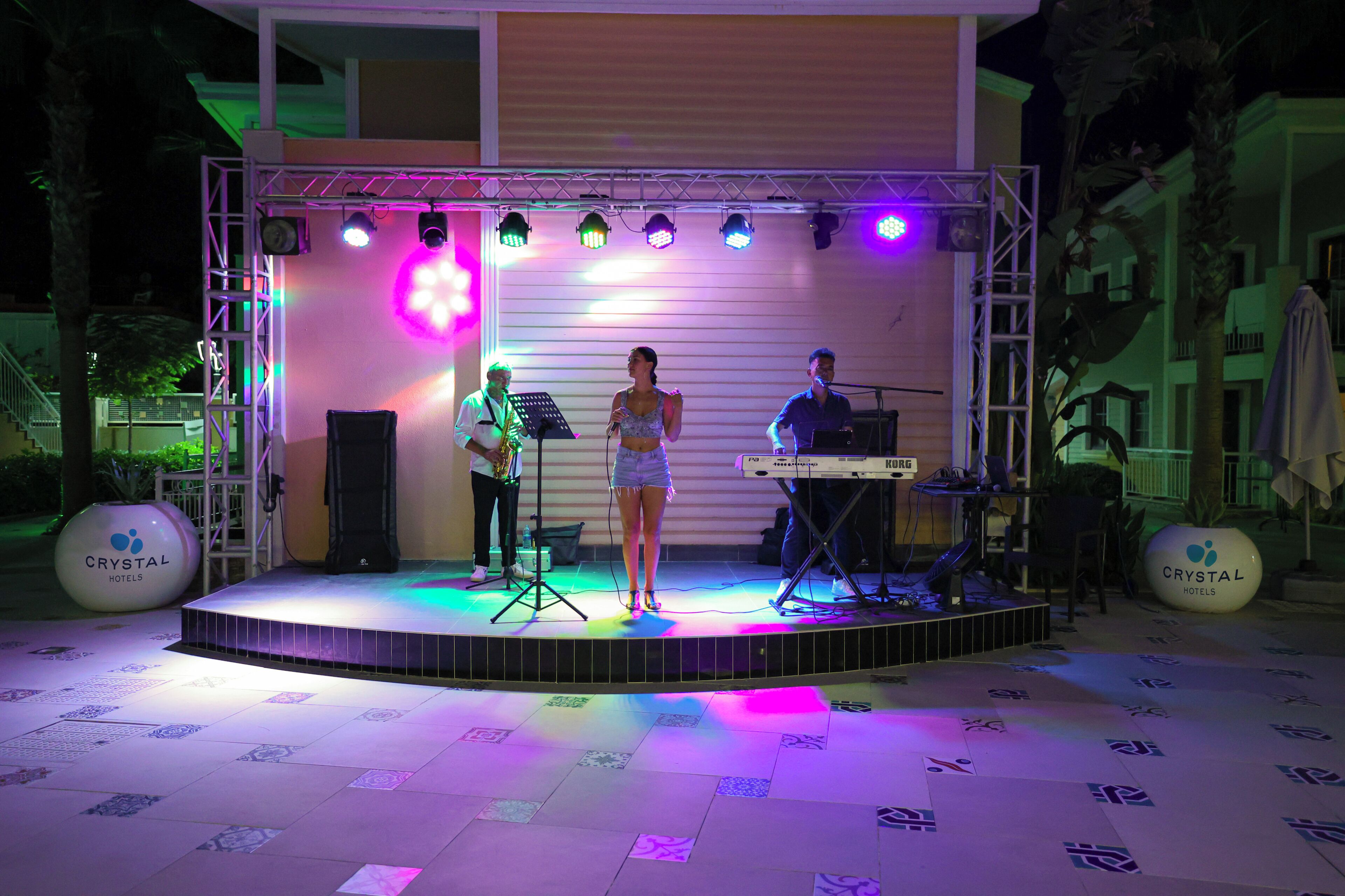 A stage with a band, a keyboard, and a microphone stand.