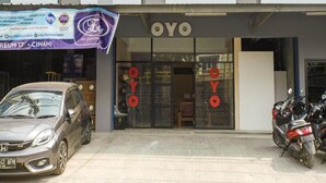 A building with a sign reading "OYO" and a banner above the entrance. - OYO 3462 Cimindi Residence (Cimahi)