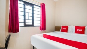 A hotel room with a bed, a chair, and a window with curtains. - OYO 3462 Cimindi Residence (Cimahi)