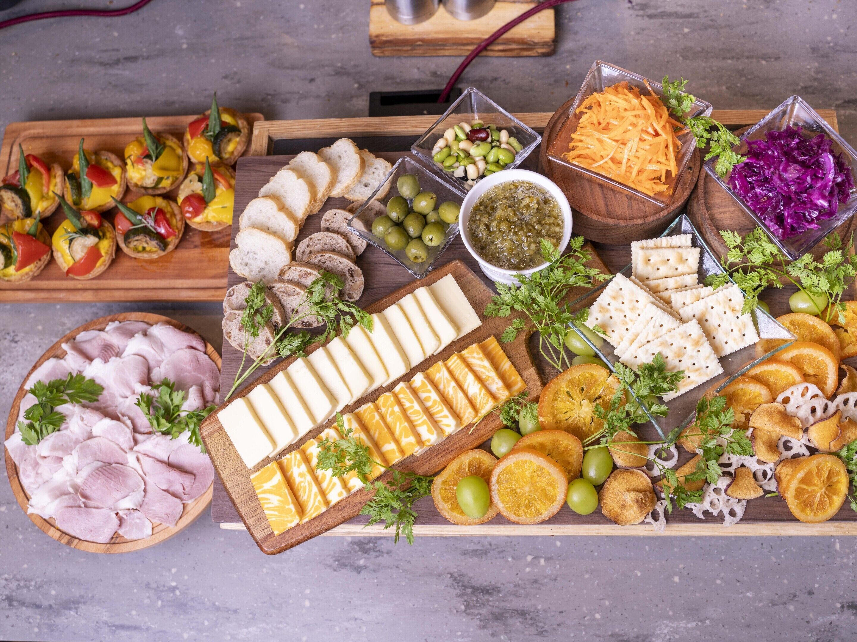 A charcuterie board with various meats, cheeses, and fruits.