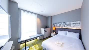 A hotel room with a large bed, a desk, a chair, a bench, and a window.