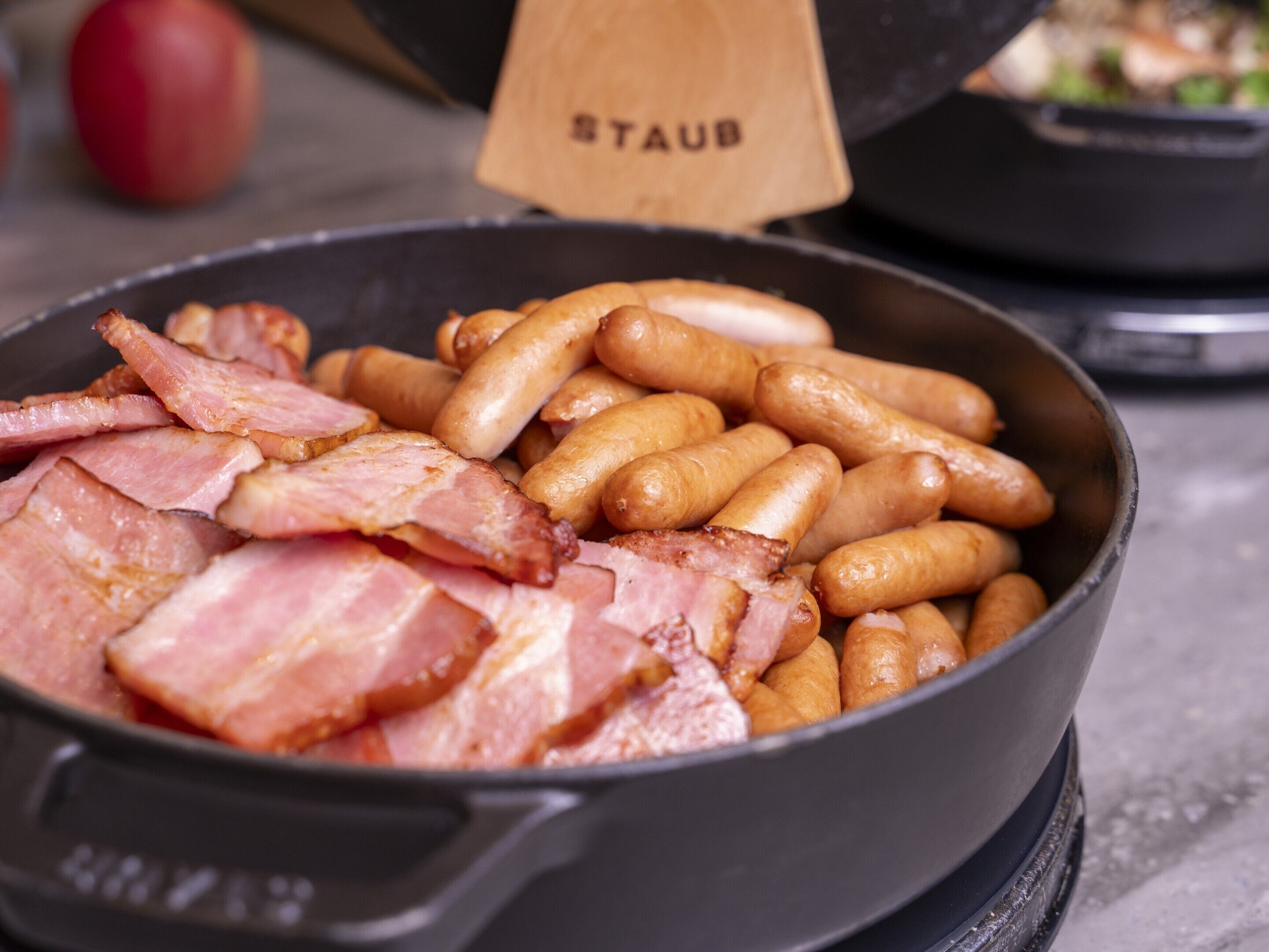 Una sartén con tocino y salchichas.
