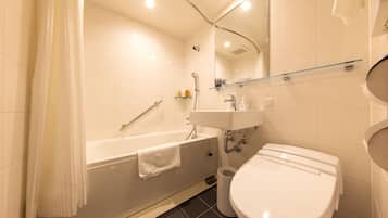 Et moderne badeværelse med badekar, toilet og håndvask.