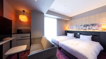 A hotel room with a bed, a desk, a chair, and a TV.