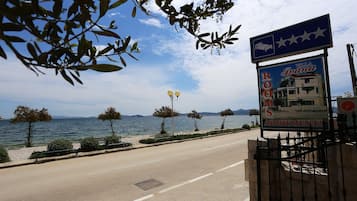 A signboard for Villa Guana with a view of the sea and mountains in the background.
