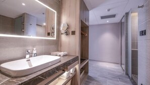 A modern bathroom with a large mirror, a bathtub, and a shower area. - Atour Hotel (Xi'an)