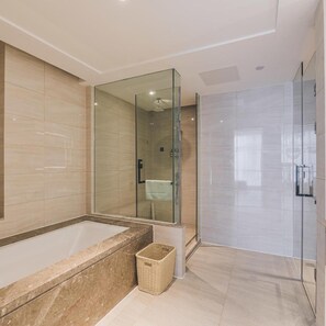 Une salle de bain moderne dotée d’une douche à parois de verre, d’une baignoire sur pieds et d’un lavabo fixé au mur.