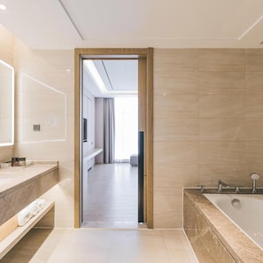 A modern bathroom with a bathtub, a vanity with a mirror, and a shower area.