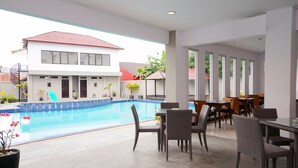 Un hôtel moderne doté d’une piscine, d’un espace de restauration en plein air et offrant une vue sur le quartier environnant.