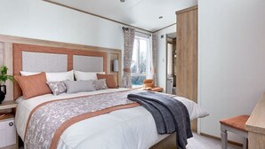 Une chambre à coucher avec un grand lit, une table de chevet, une chaise et une armoire.