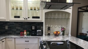 A kitchen with white cabinets, a black stove, and a marble countertop. - Great Monthly Furnished Apartment in Downtown LR (Little Rock)